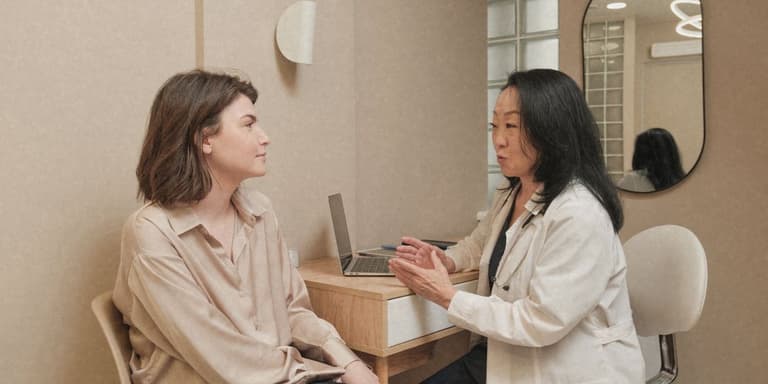 Ärztin im Beratungsgespräch mit einer Patientin in einer hellen Praxis.
