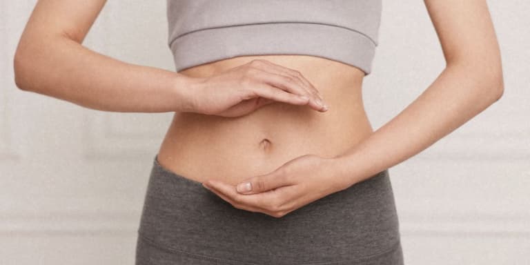 Eine Frau die mit ihren Händen einen Kreis um ihren Bauch gestikuliert.