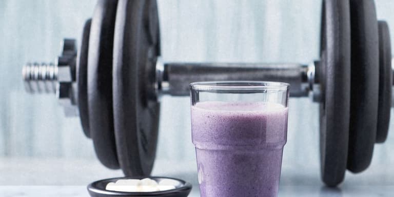 Eine Hantel und ein Kreatin Shake.