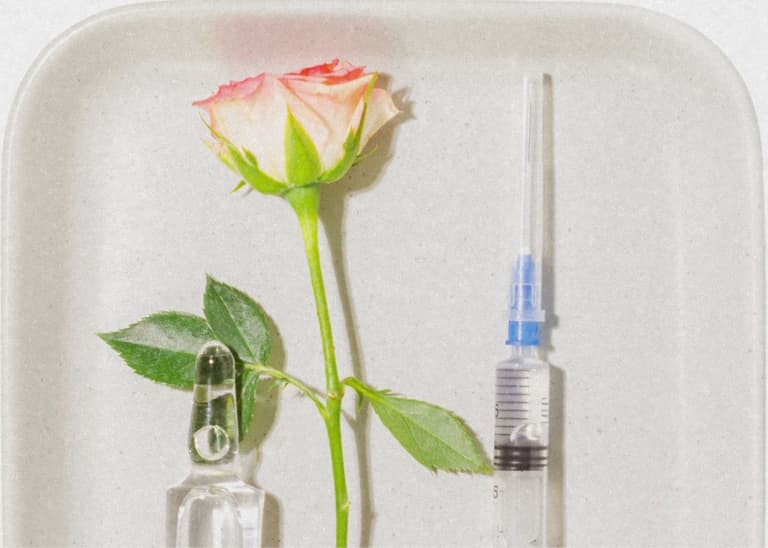 Eine Rose und eine Spritze auf einem Tablett.